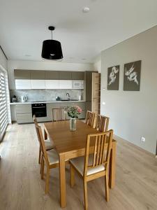 a kitchen and dining room with a wooden table and chairs at Raudondvaris holiday home in Raudondvaris