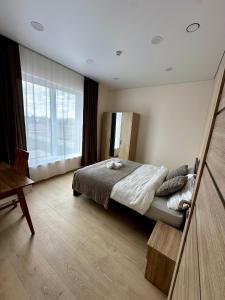 a bedroom with a bed and a large window at Raudondvaris holiday home in Raudondvaris