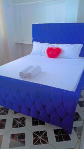 a blue bed with a red heart on a pillow at Reign homes in Watamu +4 photos