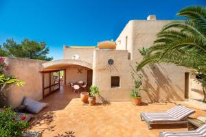 a home with a patio with chairs and a palm tree at Sa Paret Nova in Sant Francesc Xavier