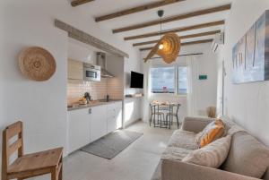 a living room with a couch and a kitchen at El Jable Rentals in Arrieta