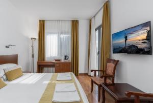 a hotel room with a bed and a desk and chair at Hotel Petrovac in Petrovac na Moru +46 photos