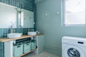 a bathroom with a sink and a washing machine at La Pause Picarde - Baie De Somme 1 in Franleu