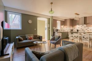 a living room with two couches and a kitchen at La Pause Picarde - Baie De Somme 1 in Franleu