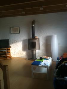 a living room with a tv and a table at L'ancien Gonio de l'Île in Lampaul +7 photos