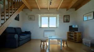 a living room with a blue couch and a table at L'ancien Gonio de l'Île in Lampaul