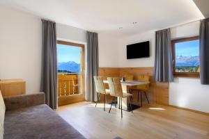 ein Wohnzimmer mit Tisch und Blick auf die Berge in der Unterkunft Tratterhof in Avelengo