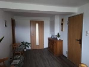 an empty room with a door and a wooden cabinet at Zimmer Edith in Gersfeld +8 photos