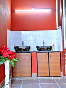 a bathroom with two sinks and a red wall at Coffee Crown Homestay - 1km to Falls, Estate, Home Food in Sakleshpur +52 photos