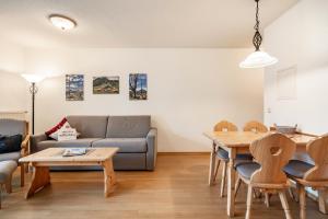 a living room with a couch and a table at Fewo Brünnstein - Nr 11 Pool, Sauna in Oberaudorf