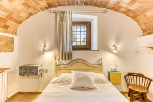 a bedroom with a bed with a brick wall at Mas la Ginesta in Borrassá +99 photos
