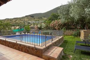 a swimming pool with a fence around it at Alojamiento Rural La Ventilla in Arbuniel