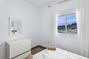 a white bedroom with a bed and a window at Atico martin in San Nicolás