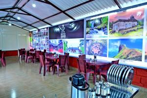 a restaurant with tables and chairs and large posters on the wall at Coffee Crown Homestay - 1km to Falls, Estate, Home Food in Sakleshpur