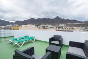 a balcony with chairs and a table and mountains at Atico martin in San Nicolás