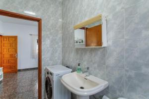 a bathroom with a sink and a washing machine at Atico martin in San Nicolás +13 photos