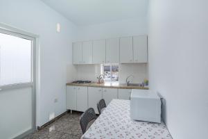 a kitchen with white cabinets and a table and chairs at Atico martin in San Nicolás