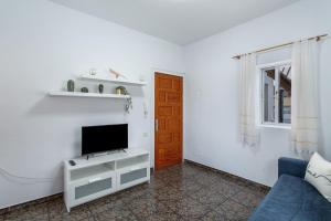a living room with a tv and a blue couch at Atico martin in San Nicolás