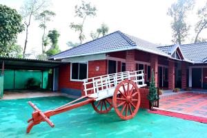 a house with a wooden wagon in front of it at Coffee Crown Homestay - 1km to Falls, Estate, Home Food in Sakleshpur
