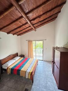 a bedroom with a bed and a large window at Alegría Lodge in Curití