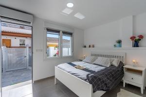 a white bedroom with a bed and a balcony at Loft A'ca La Puri en Melegís in Melegis