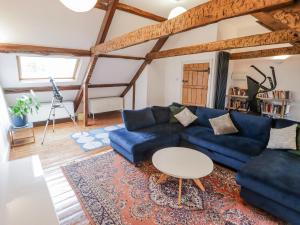a living room with a blue couch and a table at The Secret Garden in Narberth