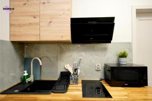 a kitchen with a sink and a microwave at MMRent Colorful Room in Gdańsk
