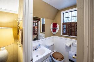 a bathroom with a toilet and a sink and a window at Hilltop Loft in Helen