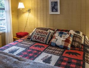 a bed with a quilt that says cash is my happy place at Hilltop Loft in Helen +1 photo