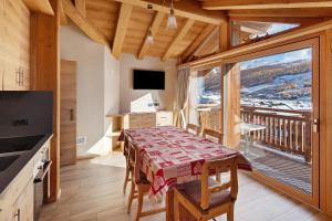 a dining room with a table and a balcony at Livigno Wooden House in Livigno