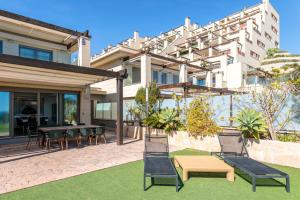a patio with chairs and a table in front of a building at Mediterranean Beach in Arenales del Sol