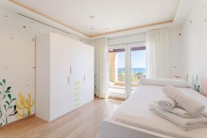 a white bedroom with a bed and a window at Mediterranean Beach in Arenales del Sol +26 photos