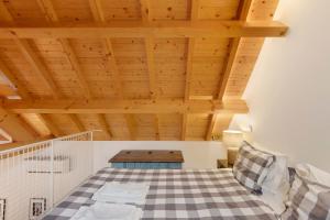 a bedroom with wooden ceilings and a checkered floor at Orange Apartments B in Porto