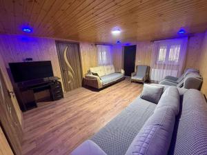 a living room with a couch and a flat screen tv at Ortabatumis house in Ch'aisubani