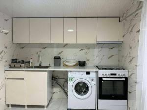 a kitchen with a washing machine and a washer at Ortabatumis house in Ch'aisubani