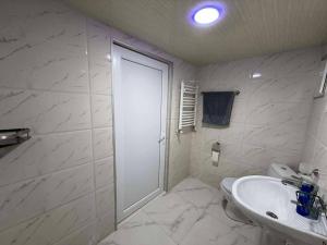 a white bathroom with a sink and a shower at Ortabatumis house in Ch'aisubani +6 photos
