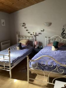 a bedroom with two beds with blue comforter at 196 rue des moulins in Vachères