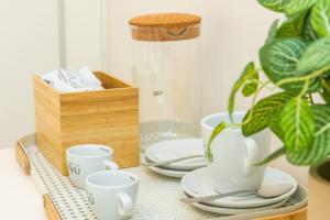 a table topped with white cups and plates and a wooden box at Hostal Boutique Canyamel in Canyamel