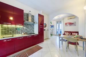 eine Küche mit roten Schränken und einem Esstisch in der Unterkunft Casa Sofìa in Turin