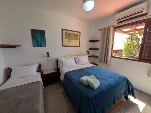 a bedroom with two beds and a window at Pousada Manacá — Beachfront Guesthouse on Ilha Grande in Abraão