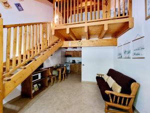 a staircase in a living room with a couch and chairs at Appartamento Adamello 12 in Pinzolo