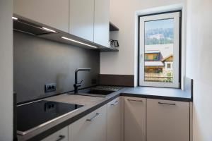 a kitchen with a sink and a window at Premium App Hofer Elisabeth in Villabassa