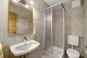 a bathroom with a sink and a shower at Premium App Hofer Elisabeth in Villabassa +17 photos