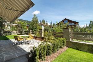 a patio with a table and chairs in a garden at Premium App Hofer Elisabeth in Villabassa
