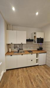 a kitchen with white cabinets and a wooden floor at CA' VARADE di Martina Scarduelli in Varallo