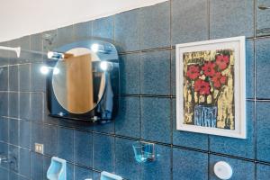 a mirror on a tiled bathroom wall with a picture at Alta Via Ligure - La Squazza in Bertigaro +31 photos