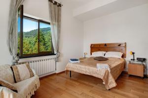a bedroom with a bed and a chair and a window at Alta Via Ligure - La Squazza in Bertigaro