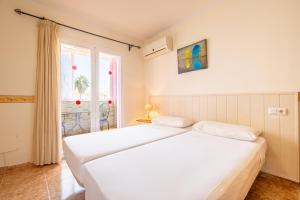 a bedroom with two white beds and a window at Villa Gaviota in Muro +21 photos