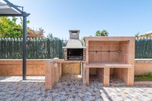 a outdoor grill with a stove on a patio at Villa Gaviota in Muro