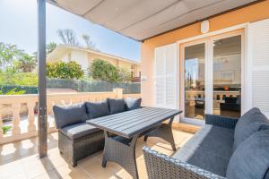 a patio with a couch and a table and chairs at Villa Gaviota in Muro